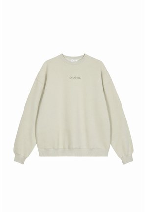 Lys beige genser med rund hals, ribbede mansjetter og hem, med brodert tekst "OH APRIL" i samme farge i midten.