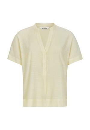 Lühikeste käistega, heledat kollast bluus, millel on V-kaelus, peene tekstuur ja neli nuppu ees. Sujuv kangas ja lõdva istuvusega.