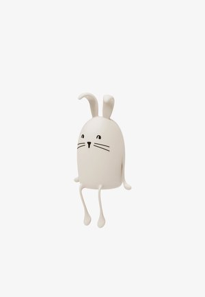 Minimalist karakter jari putih dengan mata, hidung, dan kumis hitam yang sederhana, duduk dengan kaki tergantung di latar belakang putih.