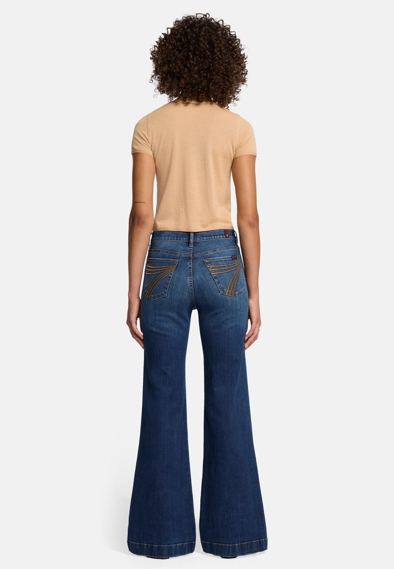 Blue flared jeans made of denim with a high waist, featuring contrast stitching on back pockets and a clean hem at the bottom.