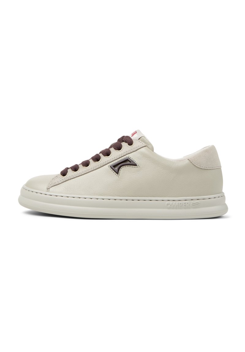 Sneaker in pelle crema con lacci marroni, punta rotonda, pannello testurizzato e dettaglio del logo in rilievo. Suola bianca con branding sottile.