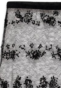 Melnas mežģīņu svārki ar ziedu akmentiņu rotājumiem. Sarežģītais raksts apvieno dažādu izmēru akmentiņus ar tekstūras mežģīņu fona.