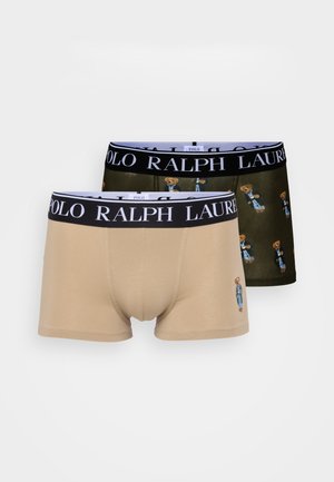 Zwei Paar Boxershorts: eine beige mit einem Bärenlogo, die andere dunkelgrün mit Bärenmustern, beide mit elastischen schwarzen Taillenbändern, die mit "POLO RALPH LAUREN" beschriftet sind.