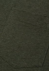 Olijfgroen textiel met een zichtbare zak, met gestikte randen en een klein boomlogo in de linkerbovenhoek van de zak.