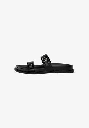 Black leather slide sandal featuring two adjustable straps with metallic buckles, flat sole, and smooth texture. Minimalist design.