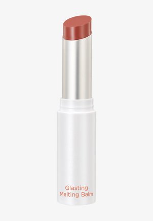 Lip balm in a white matte tube with silver accents. The balm has a reddish-brown color and a rounded tip. Label reads "Glasting Melting Balm."