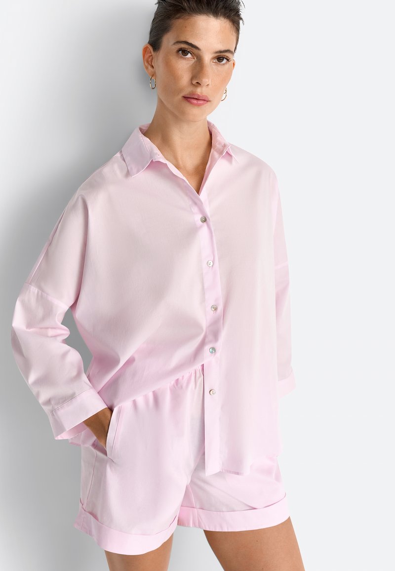 Chemise à boutons en coton rose clair à manches longues, assortie à un short avec taille élastique et poignets.