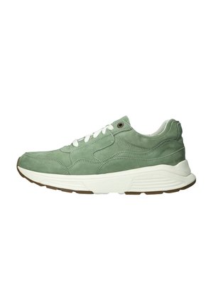 Groene suède sneaker met witte veters, dikke witte zool en bruine profielzool, zijaanzicht op witte achtergrond.