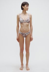 Brown floral-patterned bikini set featuring a triangular top and low-rise briefs, made of smooth fabric with adjustable straps.