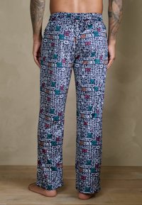 Kolorowe spodnie piżamowe z zabawnym wzorem twarzy zwierząt na granatowym tle. Elastyczny pas, luźny krój, lekki materiał.