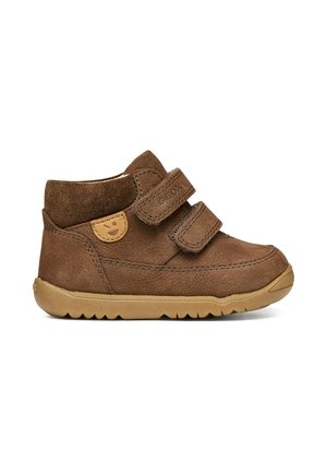 Zapato infantil marrón de caña alta con doble cierre de velcro y suela de goma, con un pequeño logo de cara sonriente en el lateral.