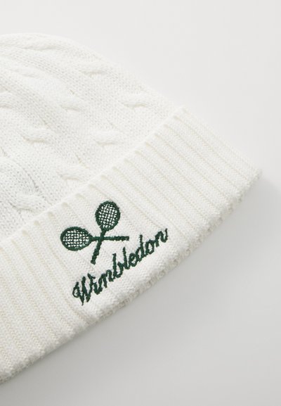 Valge kootud müts, millel on tekstuuritud muster, soonikäär ja rohelised tikitud tennisereketid koos "Wimbledon" tekstiga.