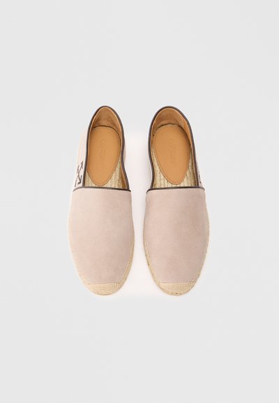 Bežiniai su stuomenu batai su austine džuto padais, turintys rudą odos apvadą aplink kraštą ir lygią vidinę pamušalą.