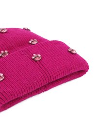 Beanie rosa a maglia con texture a costine, decorato con piccoli gemmi scintillanti disposti in un motivo floreale sulla superficie.