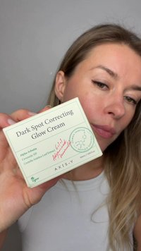 Quadratische, hellgrüne Box der Dark Spot Correcting Glow Cream mit botanischem Design. Text hebt Inhaltsstoffe hervor, Größe 50 ml, veganes Label sichtbar.