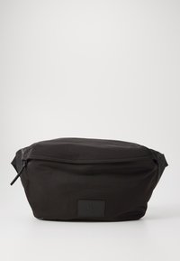 Marsupio in nylon nero con zip nella parte superiore, dotato di un'etichetta logo rettangolare. Il marsupio ha una superficie liscia e un design minimalista.
