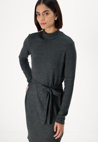 Abito lungo grigio scuro a maniche lunghe con colletto alto e una cintura legata in vita. Texture liscia e design semplice, adatto per diverse occasioni.