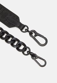 Chaîne métallique noire avec deux mousquetons attachés à une sangle en tissu noir avec des détails en cuir.