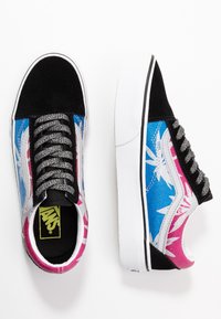 Baskets en daim noir et bleu avec des motifs de feuilles roses et bleues, des lacets argentés, une semelle intermédiaire blanche et une semelle intérieure noire et jaune à logo.