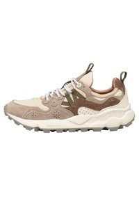 Beige und braune Wildleder- und Ledersneaker mit einer strukturierten Sohle, weißen Schnürsenkeln und einem markanten Design mit Ausschnitten und einer Schlaufe am Rücken.