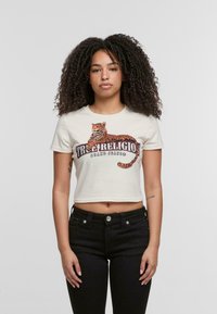 Kruta krem majica s kratkim rukavima s grafikom narančastog i crnog tigra i natpisom "True Religion Brand Jeans." Jednostavna tekstura.