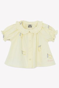 Yellow blouse with short puff sleeves, ruffled collar, fruit embroidery, and button closure. Features brand name stitched in pink.