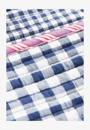 Prešívaná tkanina s alternujúcimi modro-bielymi kockami, s červeným pruhom ako akcentom. Mäkka textúra.