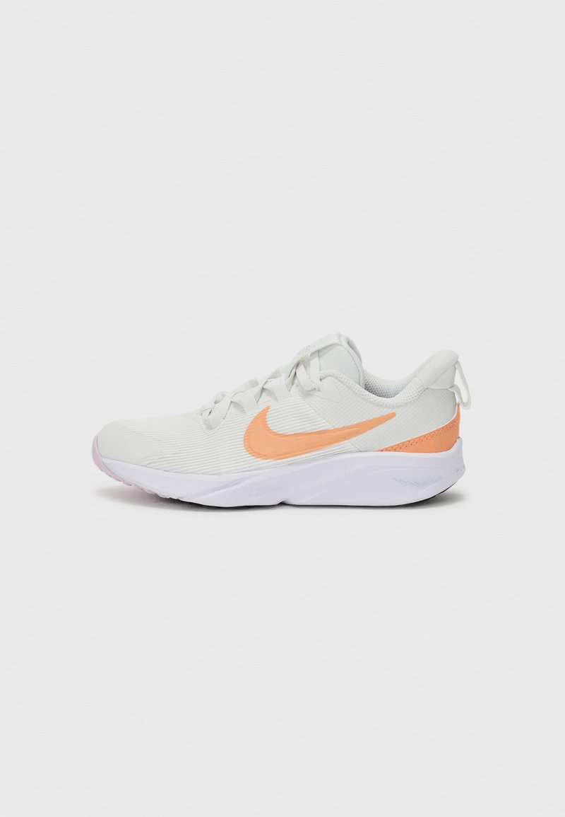 Baskets blanches avec tige texturée, logo Nike en orange, et semelle en caoutchouc souple. Dotées d'un système de laçage et d'un col rembourré pour le confort.
