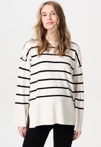 Sweter w paski w kolorze kremowym z czarnymi poziomymi pasami, z długimi rękawami, luźnym krojem i bocznymi rozcięciami dla większej swobody ruchów.