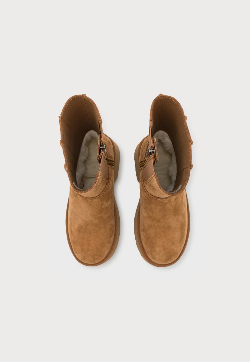 Braune Wildleder-Stiefeletten mit einem weichen, hellen Innenfutter, ausgestattet mit einem seitlichen Reißverschluss und einem runden Zehendesign.