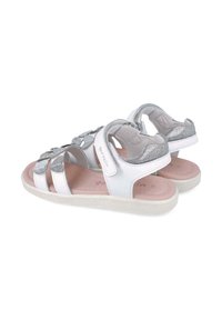 Sandalias blancas con acentos plateados, correas y herrajes decorativos. Suela texturizada, plantilla acolchada en color rosa y diseño de talón seguro.