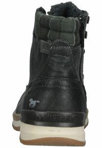 Bottine en cuir noir avec un revers en textile à carreaux verts, fermeture éclair, semelle en caoutchouc et un petit logo de cheval sur le côté.