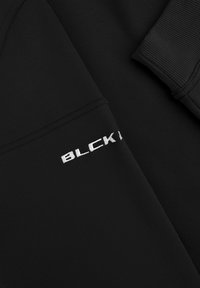 Zwarte sweatshirt met geribbelde manchetten en een "BLCK" logo in witte borduursel op de mouw. Zacht, gestructureerd materiaal met een aangesloten pasvorm.