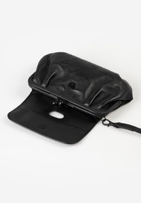 Black leather clutch purse with a flap open, featuring a kiss-lock frame and a detachable wrist strap on a white background.