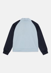 Lichtblauwe sweatshirt met donkermarine raglanmouwen, hoge kraag en elastische manchetten. Gladde textuur, eenvoudig ontwerp.