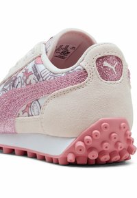 Sneakers Puma w różowym brokacie i wykończeniu z zamszu. Posiadają wzorzystą cholewkę i teksturowaną gumową podeszwę z różowymi ćwiekami dla lepszej przyczepności.