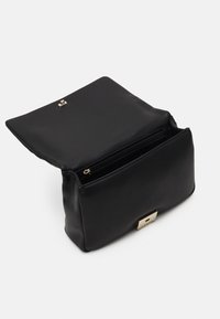 Sacoche en cuir noir avec une texture lisse, fermeture zippée sur le dessus et accent en métal doré à l'avant. Forme compacte et rectangulaire.