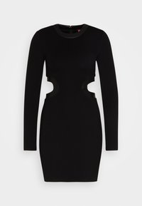 Robe bodycon noire à manches longues avec des découpes sur les côtés et un col rond avec des bordures en simili cuir.