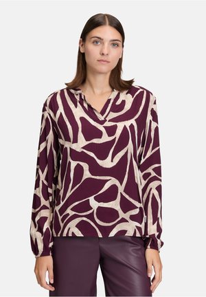 Blusa a maniche lunghe di un profondo bordeaux con motivo astratto beige, caratterizzata da un colletto pieghettato e polsini arricciati, realizzata in tessuto leggero.