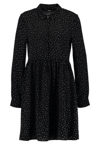 Robe noire à manches longues, avec un plastron de boutons et un col. Présente une taille froncée avec un motif à pois blancs sur l'ensemble. Tissu lisse.