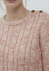 Maglione a costine in morbido colore pesca, con scollo a costine e due bottoni decorativi marroni sulla spalla.