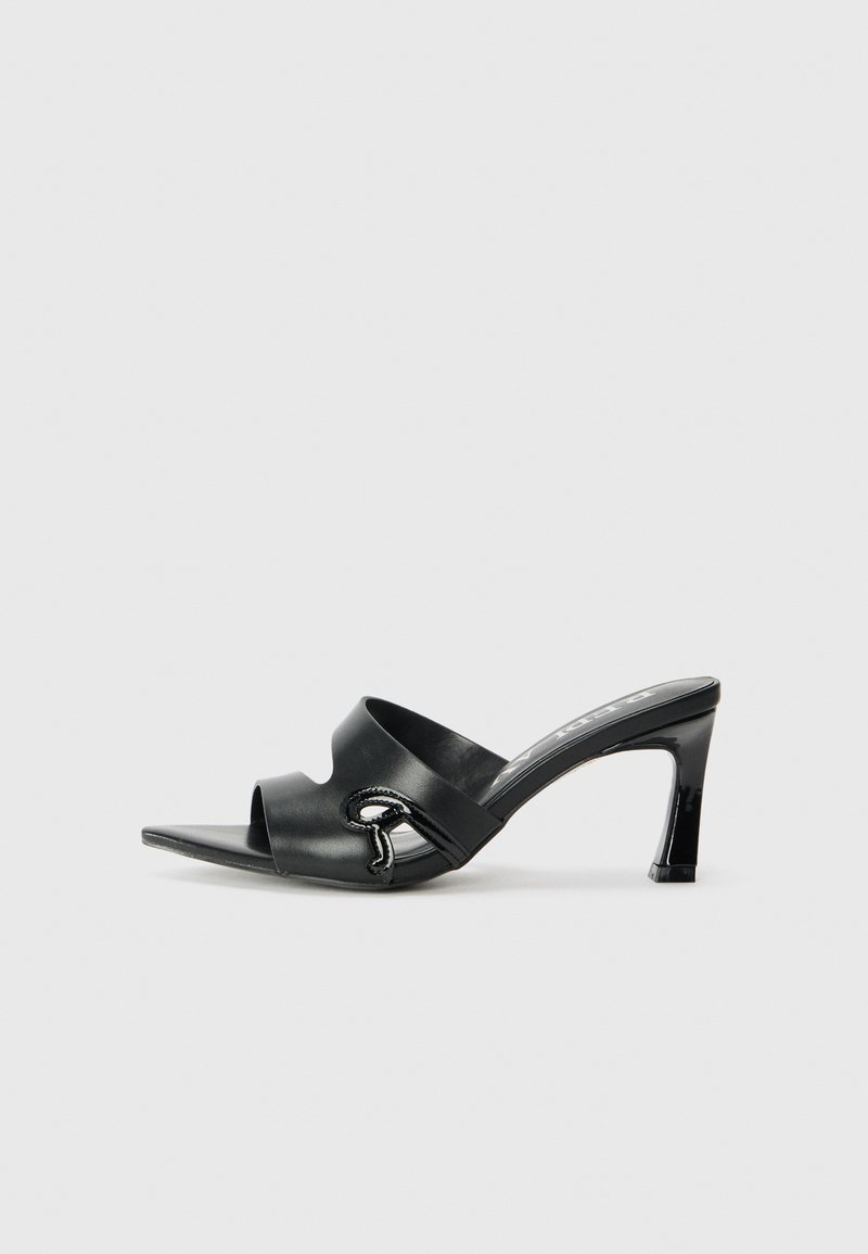 Mules noirs à talons hauts avec un bout ouvert, en cuir lisse, présentant un détail décoratif en forme de serpent sur le côté.