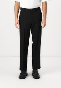 Svarta rakbenade byxor i ett glatt material har en veck fram, knappstängning och bältesöglor.