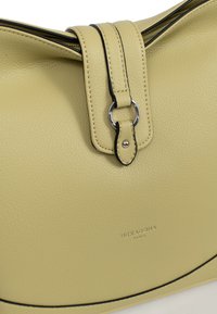 Geel leren schoudertas met een gestructureerd oppervlak, voorzien van een bovenklep, zwarte stikselaccenten en een zilveren ronde hardware detail.