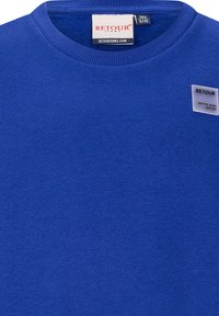 Felpa blu in cotone con collo a coste. Presenta un'etichetta RETOUR cucita sul petto con una texture liscia e senza motivi visibili.