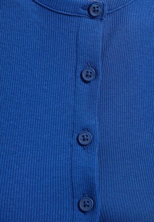 Blauer gerippter Stoff mit vier passenden blauen Knöpfen, die in einer vertikalen Linie in der Mitte angenäht sind.