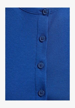 Blauer gerippter Stoff mit vier passenden blauen Knöpfen, die in einer vertikalen Linie in der Mitte angenäht sind.
