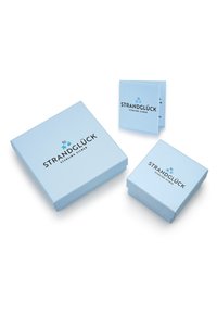 Lysblå emballagekasser med en mat finish. Stor kasse med "STRANDGLÜCK STERLING SILBER" trykt i mørk skrift, ledsaget af to mindre kasser.