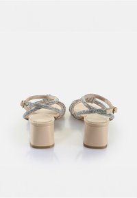 Beige korkokenkiä, joissa on ristikkäiset remmit, joissa on monivärisiä helmiakselointeja ja sileä, paksu korko.