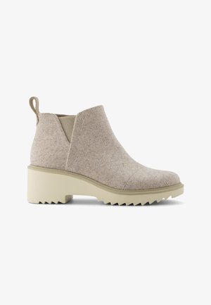 Stivaletto beige con tomaia in tessuto strutturato, suola spessa scanalata, tacco basso, pannello laterale elastico e linguetta sul retro.